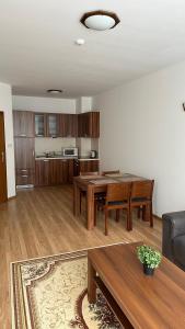 a living room with a table and a couch at Апартамент в затворен комплекс Рила парк-Конярски в курорта Боровец in Borovets +12 photos
