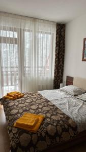a bedroom with a bed with two towels on it at Апартамент в затворен комплекс Рила парк-Конярски в курорта Боровец in Borovets
