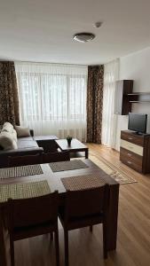 a living room with a couch and a table at Апартамент в затворен комплекс Рила парк-Конярски в курорта Боровец in Borovets