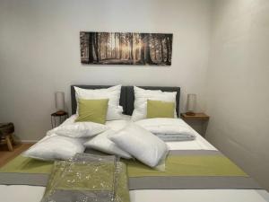 a bed with white pillows and a painting on the wall at Chalet Wildenbach by Interhome in Grafenweg