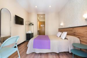 um quarto com uma cama e duas cadeiras e uma televisão em Hostal Art Madrid em Madrid
