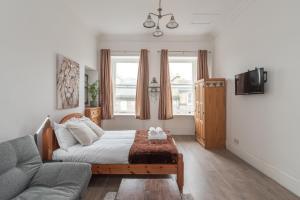 a living room with a bed and a couch at Spacious Ensuite Rooms in Edinburgh City Centre - Excellent Location in Edinburgh