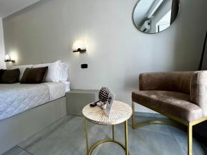 een slaapkamer met een bed, een stoel en een tafel bij Palermo Inn Boutique in Palermo