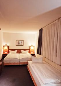 Trip Inn Hotel Minerva Frankfurt في فرانكفورت ماين: غرفه فندقيه سريرين ومصباحين