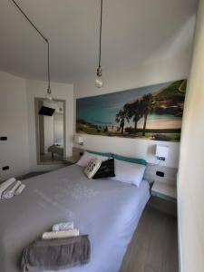 a bedroom with a white bed with a painting on the wall at Struttura Re Barbaro in Porto Torres