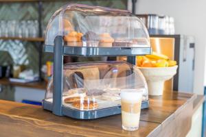 a glass display of pastries and a drink on a counter at Hotel Restaurant Toxopeus in Anjum