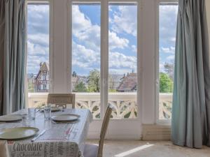 comedor con mesa y ventana grande en Apartment Marie Antoinette-1 by Interhome, en Cabourg