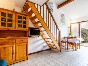 a living room with a staircase and a table with chairs at Holiday Home Hameau de Talaris-4 by Interhome in La Palmyre +19 photos