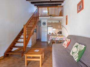 a living room with a couch and a wooden staircase at Holiday Home Les Maisons de la Plage-7 by Interhome in Le Grau-du-Roi