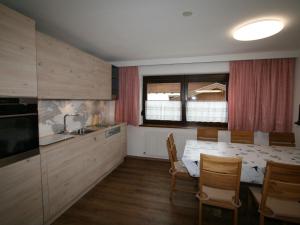 eine Küche mit einem Tisch und Stühlen sowie einem Fenster in der Unterkunft Apartment Spörr by Interhome in Matrei am Brenner