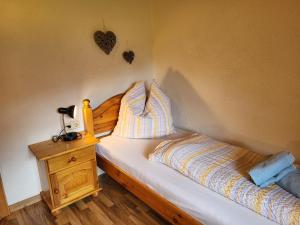 een slaapkamer met een bed en een nachtkastje met een bed sidx sidx bij Apartment Helmreich-2 by Interhome in Sankt Gallenkirch