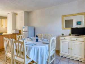 ナルボンヌ・プラージュにあるHoliday Home Les Grandes Bleues 3 by Interhomeのダイニングルーム(テーブル、椅子、冷蔵庫付)