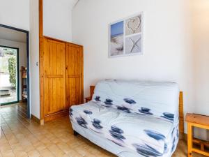 a bedroom with a bed and a clock on the wall at Holiday Home Bois d'Eleis-2 by Interhome in La Palmyre