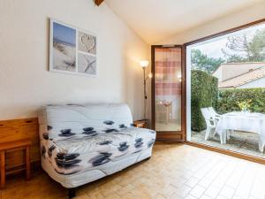 ラ・パルミールにあるHoliday Home Bois d'Eleis-2 by Interhomeのベッド、テーブル、ガラスドアが備わる客室です。