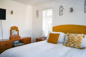 - une chambre avec un lit blanc et une tête de lit en bois dans l'établissement Badgers Run, à Sandown