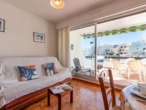 a living room with a couch and a balcony at Apartment Les Marinas de la Plage I-1 by Interhome in Le Grau-du-Roi