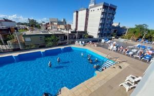 uma grande piscina com pessoas na água em Grand Hotel by MH em Termas de Rio Hondo