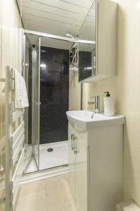 La salle de bains est pourvue d'une douche et d'un lavabo. dans l'établissement Contemporary 3 Bed City Centre Appartment - Ensuite, à Édimbourg