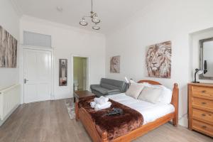 1 dormitorio con 1 cama y 1 sofá en Contemporary 3 Bed City Centre Appartment - Ensuite en Edimburgo