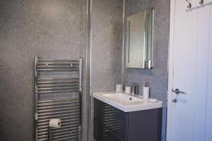 un baño con lavabo y espejo en Badgers Run, en Sandown 18 fotos más