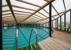 a swimming pool on a deck with a roof at Barn Owl Oxley Dairy in Hollesley