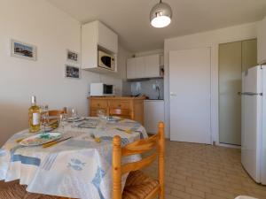 eine Küche mit einem Esstisch und einem weißen Kühlschrank in der Unterkunft Studio Los Amigos-9 by Interhome in Le Grau-du-Roi