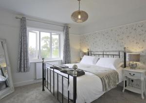 a bedroom with a large bed and a window at Bon Amis in Southwold