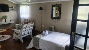 a bedroom with a bed and a chair and a mirror at Log in @ 118 Self Catering Unit in Meyerton