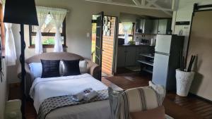 a bedroom with a bed and a kitchen with a refrigerator at Log in @ 118 Self Catering Unit in Meyerton