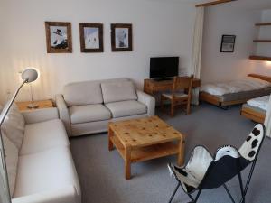 ein Wohnzimmer mit einem Sofa und einem Tisch in der Unterkunft Apartment Guardaval - Utoring-36 by Interhome in Davos
