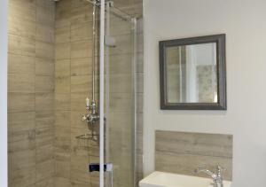 a bathroom with a shower with a sink and a mirror at Braeside House in Reydon
