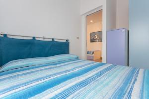 a bedroom with a bed with a blue comforter at Appartamento Stella Marina in Sottomarina