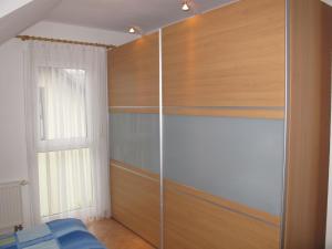 ein Schlafzimmer mit einem Schrank mit Holzregalen und einem Fenster in der Unterkunft Apartment Lemke by Interhome in Prerow