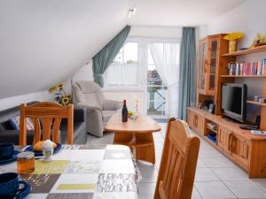 uma sala de estar com uma mesa e uma televisão em Apartment Leuchtturm by Interhome em Norddeich