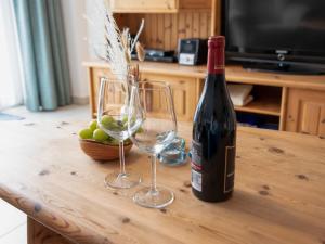 uma garrafa de vinho e dois copos de vinho numa mesa em Apartment Leuchtturm by Interhome em Norddeich