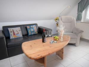 uma sala de estar com um sofá e uma mesa de madeira em Apartment Leuchtturm by Interhome em Norddeich