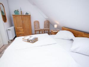 ein weißes Bett mit einem Tablett darüber in der Unterkunft Apartment Scholle by Interhome in Norddeich