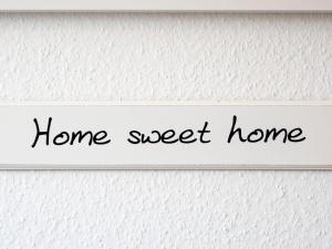 ein Zeichen, das auf einer weißen Wand das süße Heim liest in der Unterkunft Apartment Scholle by Interhome in Norddeich