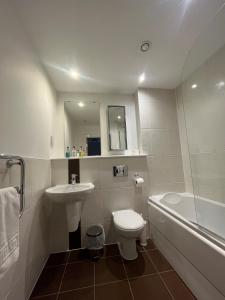 a bathroom with a sink and a toilet and a tub at Century Wharf Apartments by Urban Space in Cardiff +81 photos
