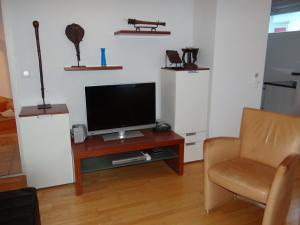 ein Wohnzimmer mit einem TV und einem Stuhl in der Unterkunft Apartment Dorfstrasse 15 by Interhome in Engelberg