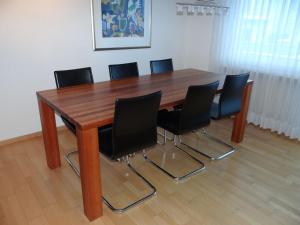 エンゲルベルクにあるApartment Dorfstrasse 15 by Interhomeの木製の会議用テーブル(黒い椅子付)