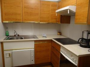 a small kitchen with wooden cabinets and a sink at Apartment Casa Lisabetha by Interhome in Engelberg