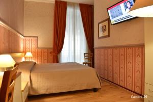 a hotel room with a bed and a flat screen tv at Catania Centro Rooms in Catania