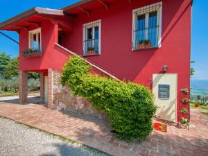 een rood huis met planten ervoor bij Holiday Home La Letizia by Interhome in Collemancio