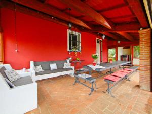 een woonkamer met een rode muur met banken en tafels bij Holiday Home La Letizia by Interhome in Collemancio