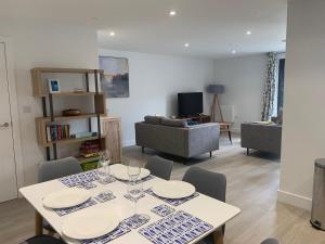 a living room with a table and chairs and a couch at 8 Middlecombe - Luxury Apartment at Byron Woolacombe, only 4 minute walk to Woolacombe Beach! in Woolacombe