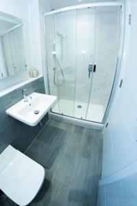 een badkamer met een douche, een toilet en een wastafel bij 8 Middlecombe - Luxury Apartment at Byron Woolacombe, only 4 minute walk to Woolacombe Beach! in Woolacombe