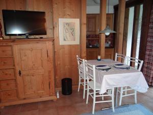 een eetkamer met een tafel en een flatscreen-tv bij Apartment Am Dürrbach 5-517 by Interhome in Engelberg