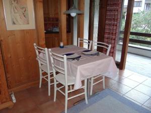 einen Esstisch mit einem weißen Tischtuch und Stühlen in der Unterkunft Apartment Am Dürrbach 5-517 by Interhome in Engelberg