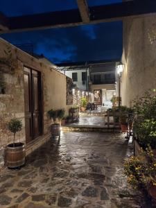 un patio al aire libre con macetas y un edificio en VIRSA BOUTIQUE ROOMS en Ioánina